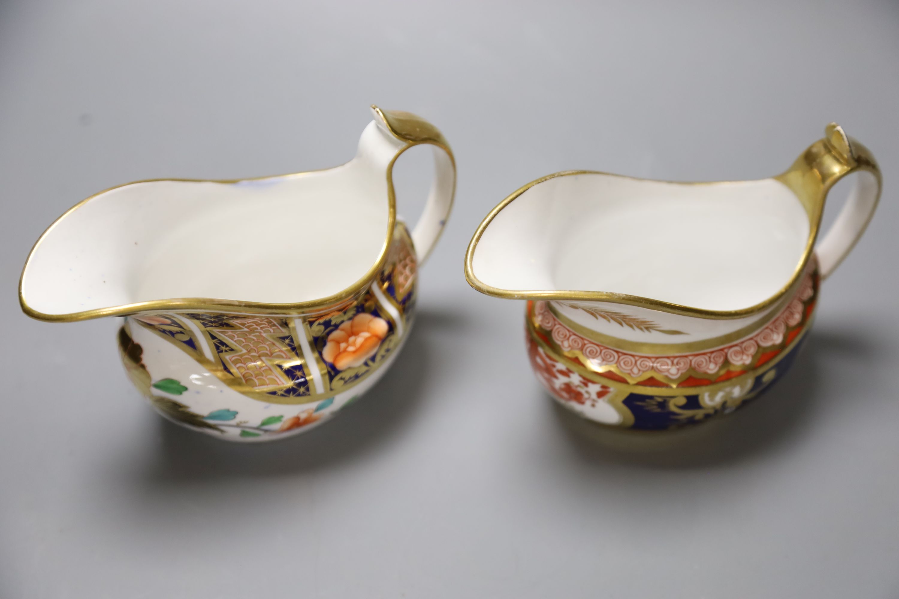 A Spode cream jug painted in imari style with the dollar pattern 715 and another Spode cream jug painted in imari style